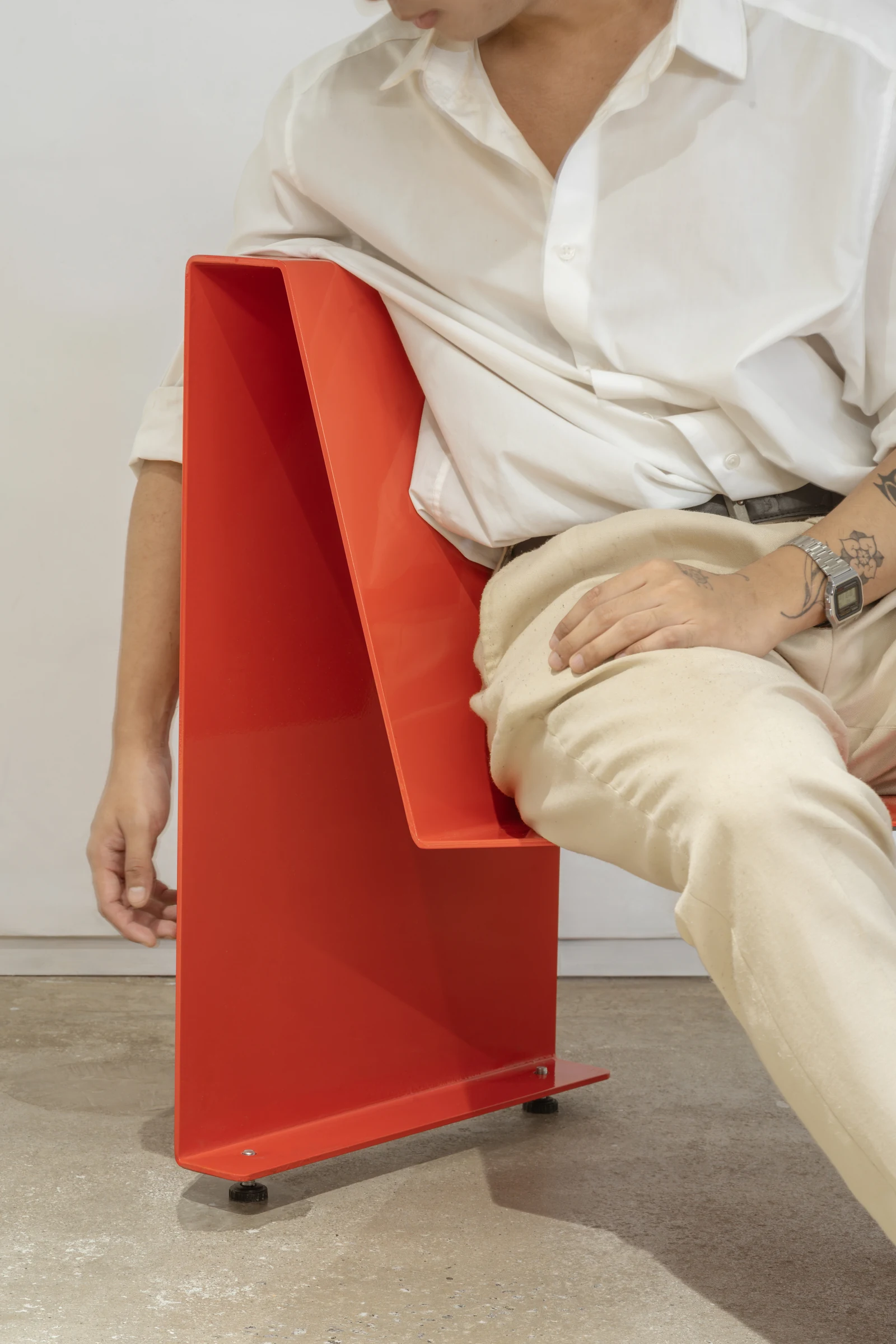 The chair in red, in use, showing its profile
