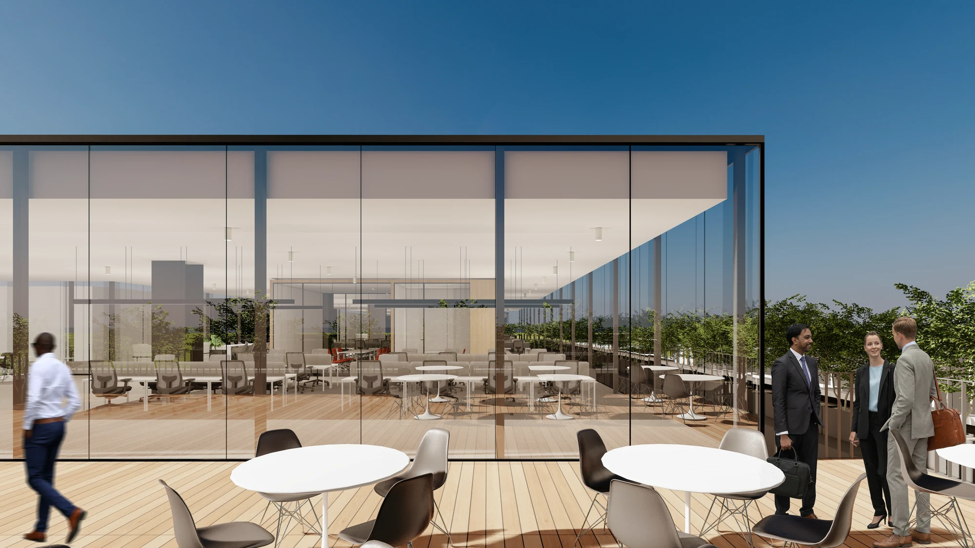 A covered outdoor lounge between buildings, glass-walled and set with seating