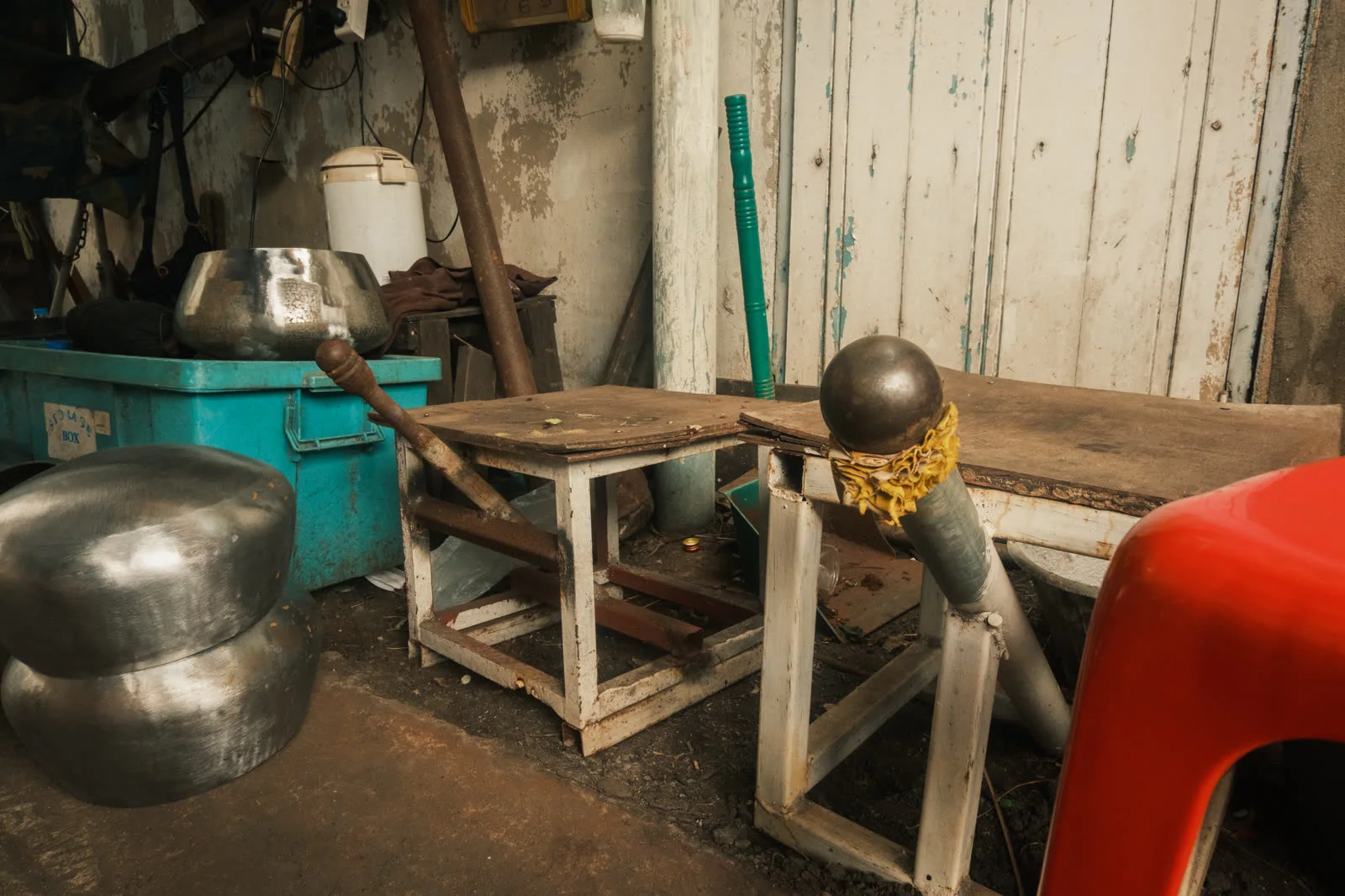 An artisan hammering a bowl against an anvil