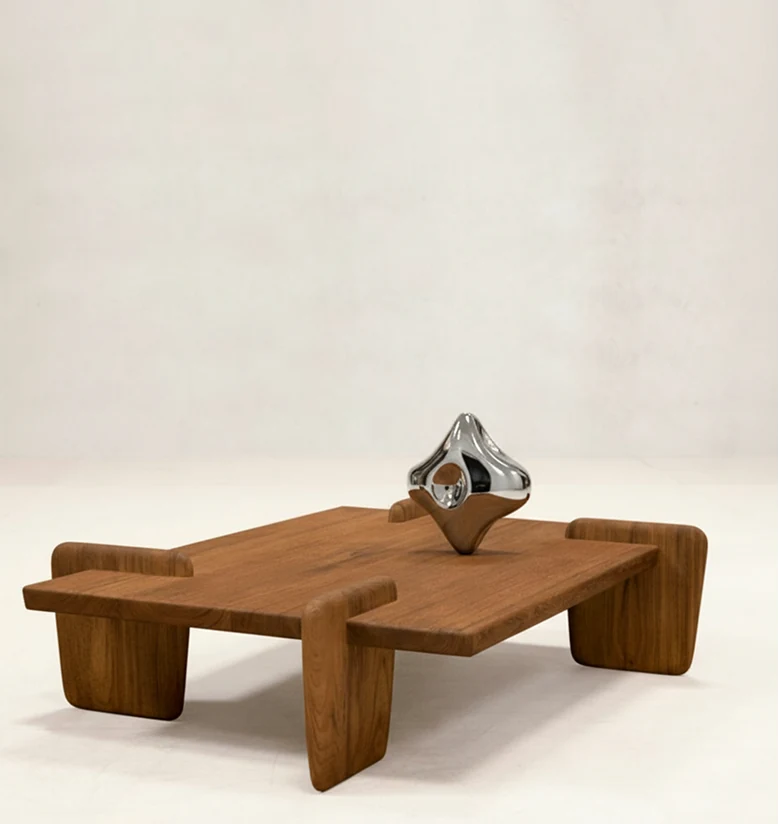 The chrome ornament displayed as an object on a minimalist wooden table