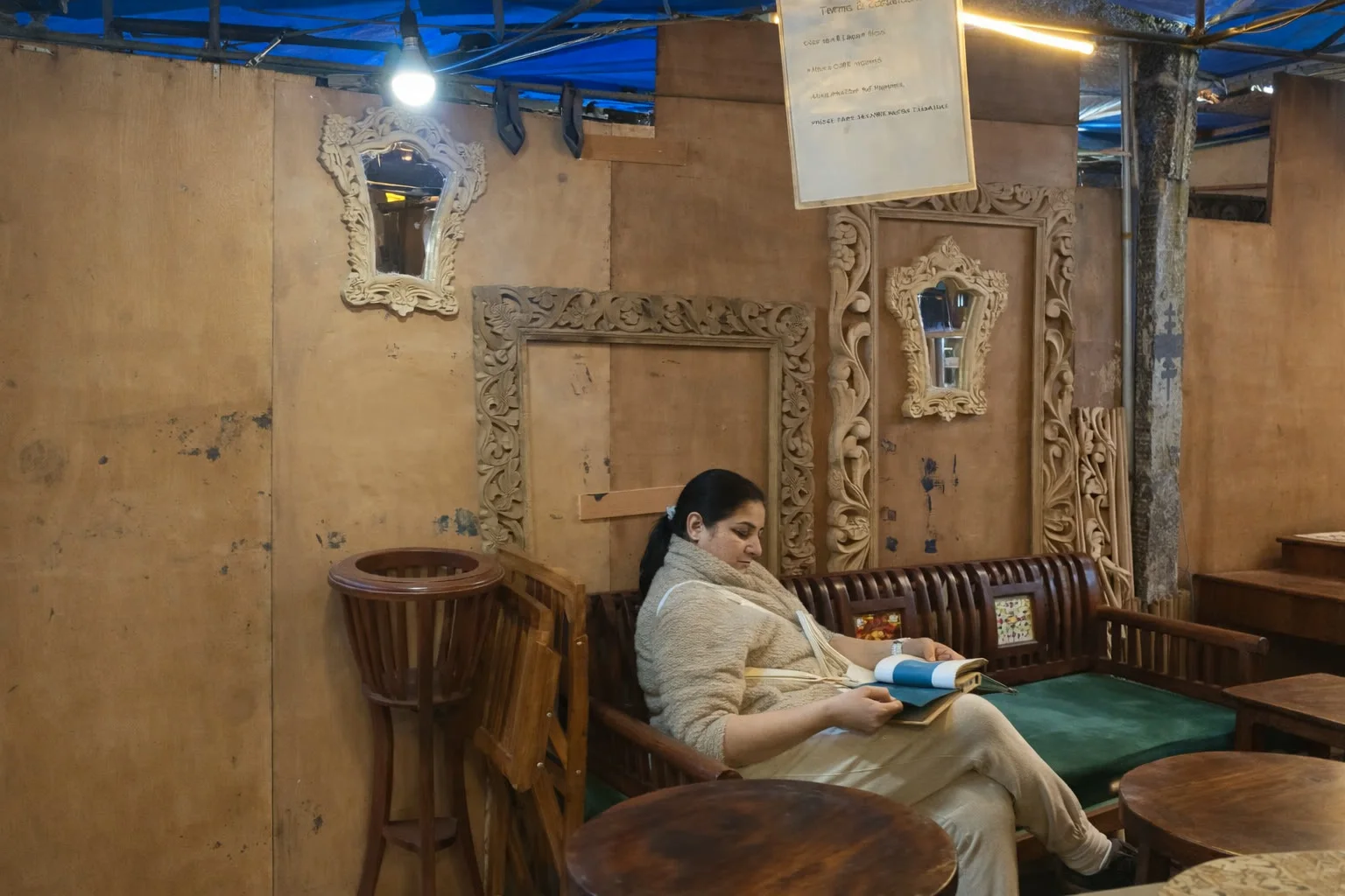 A female customer seated among carved mirror frames inside a store
