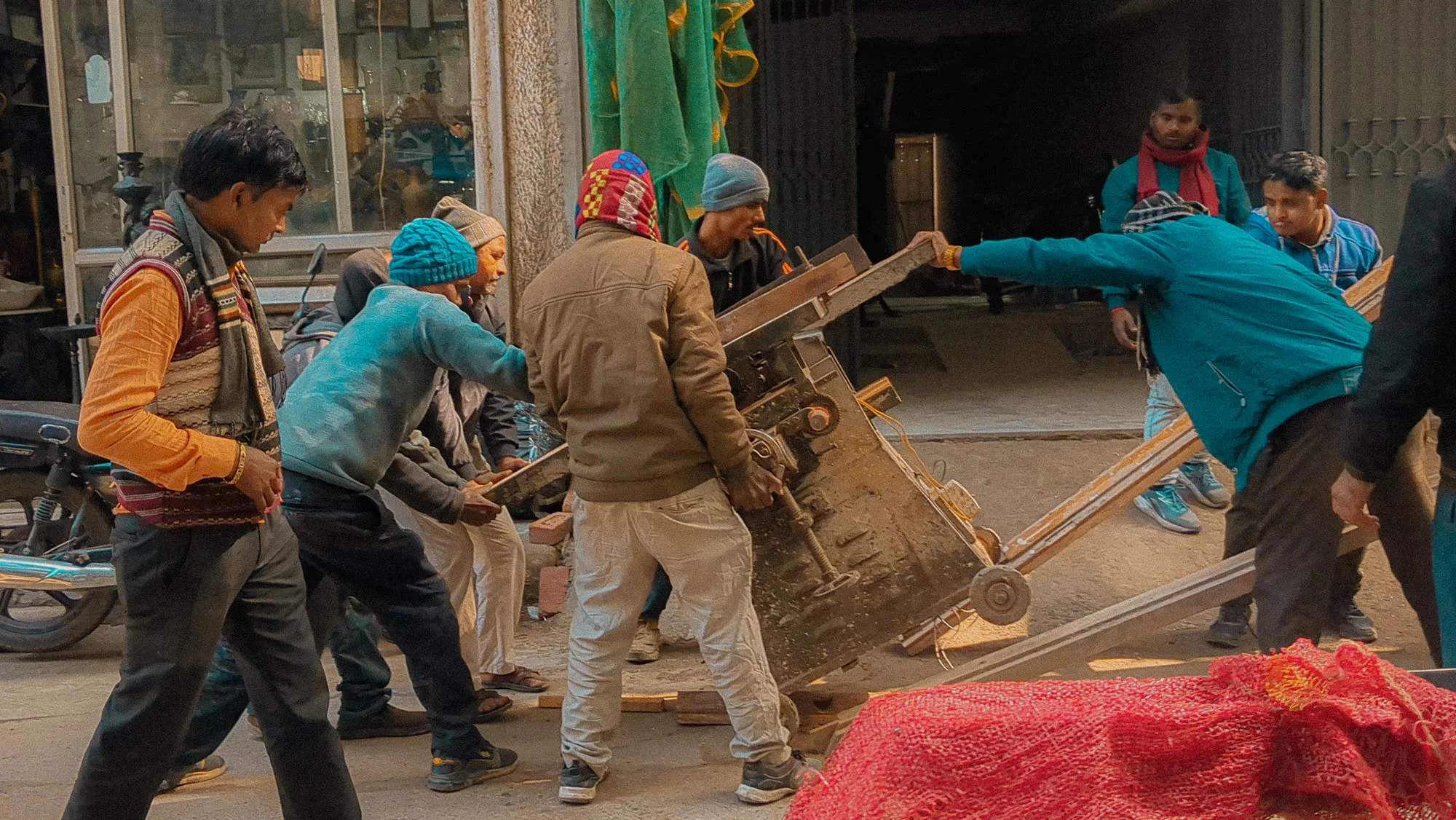 A cycle-rickshaw loader balancing furniture through the lanes